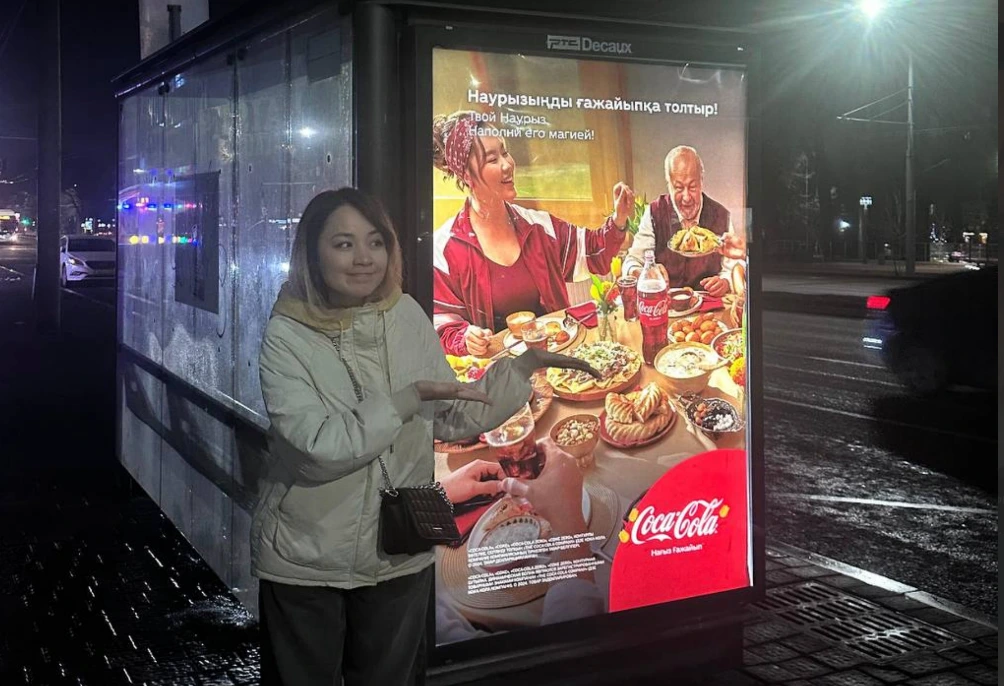 Coca-Cola printed lightbox at night — out-of-home in situ