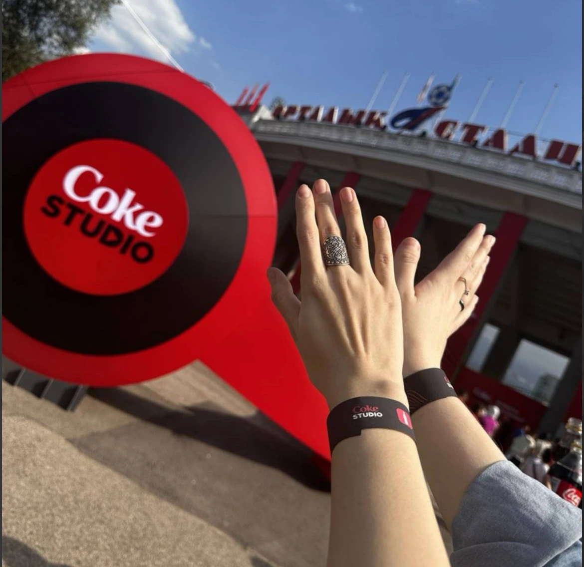 Red Coca-Cola wristband coaster held in hand